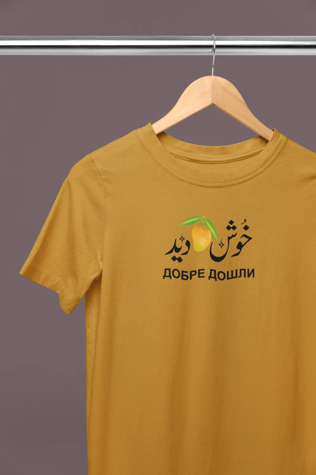 Mustard T-Shirt – “خوش آمدید ДОБРЕ ДОШЛИ” (Welcome) with Mango Graphic
